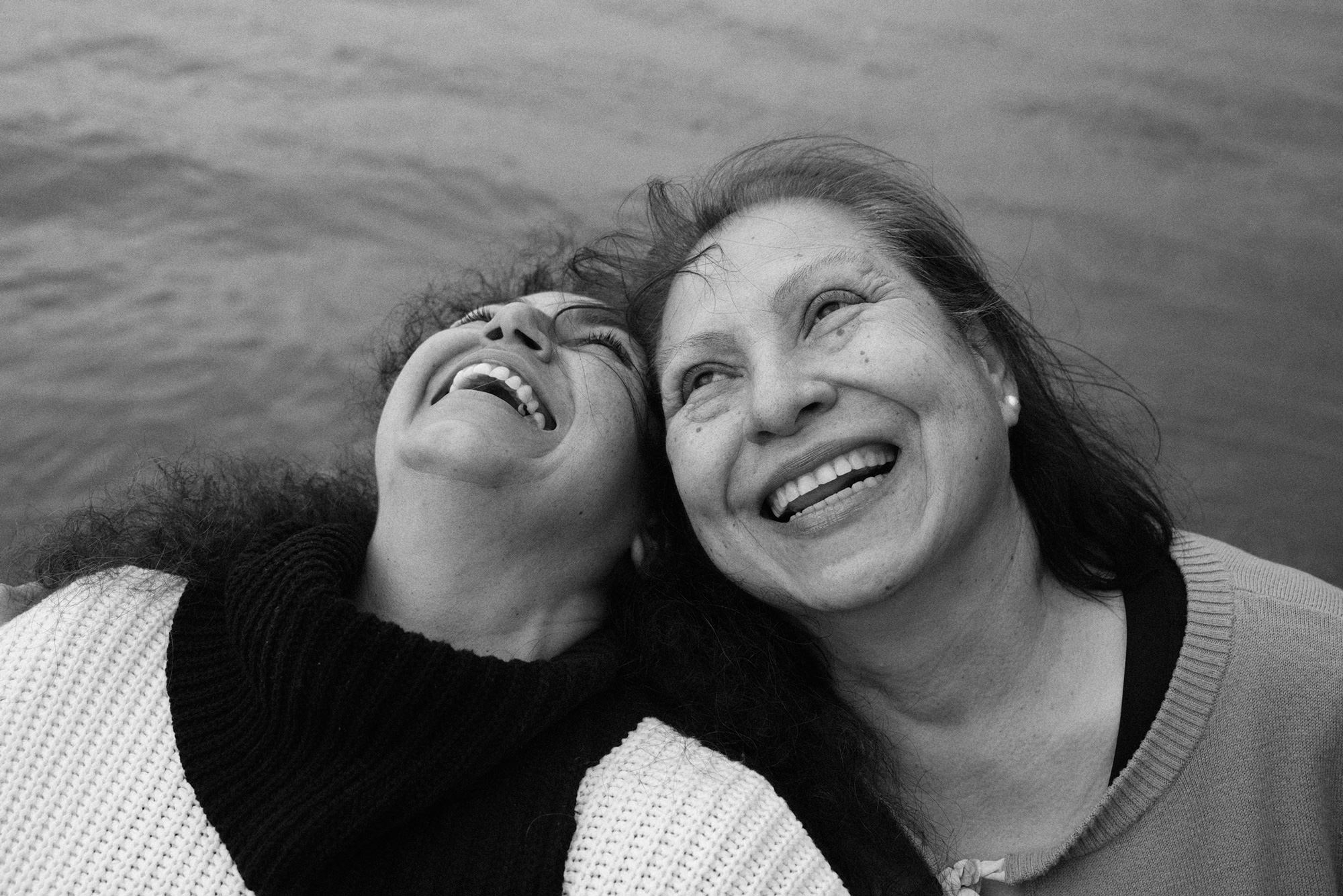 Image description: black-and-white image of the artist’s mother laughing with her aunt, looking up at the sky. Photo by Maryv Benoit.