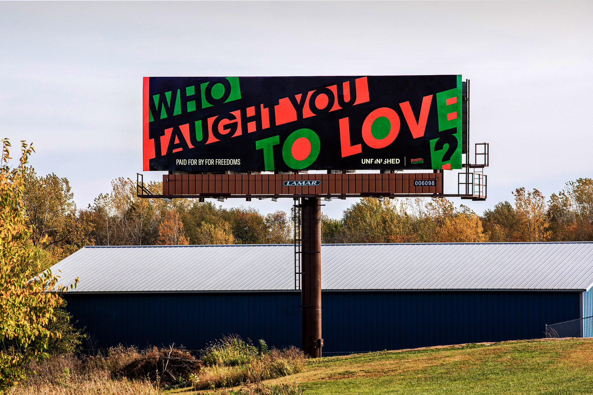 Image description: photograph of a billboard with the phrase “Who taught you to love?” in a rural, green environment. “Who Taught You to Love?” 2020 By Hank Willis Thomas, originally exhibited as part of For Freedoms’ national billboard campaign. Designed by: Sam Shmith. Photographed by: Jeff Scroggins