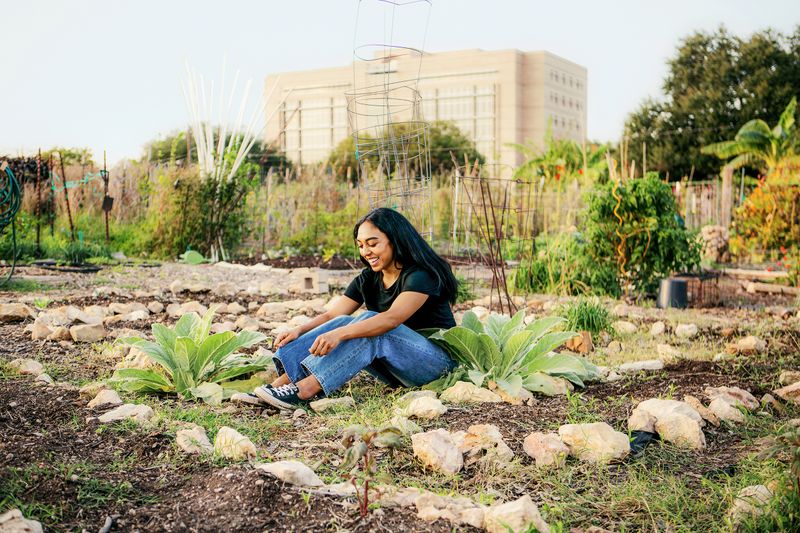 Una mujer sentada en un jardín.