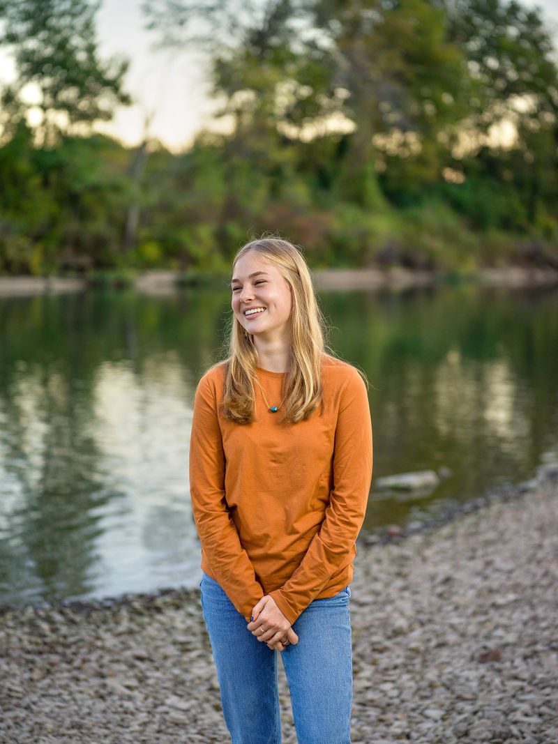 Una niña parada frente a un río